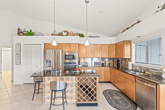 kitchen with pendant lighting, a kitchen island, light tile patterned floors, and appliances with stainless steel finishes