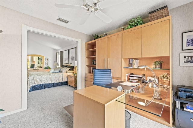 carpeted office space featuring vaulted ceiling, ceiling fan, and a textured ceiling