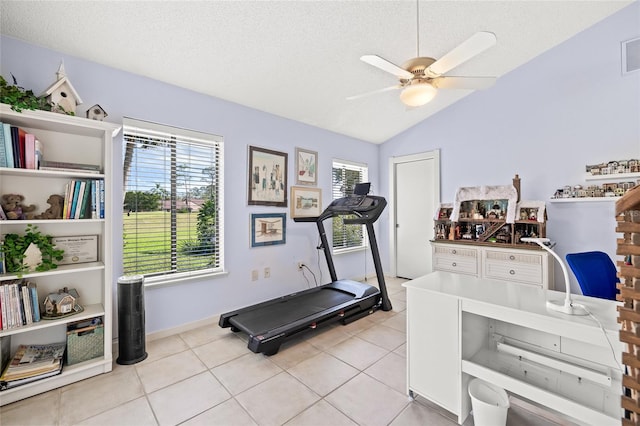 exercise room with light tile patterned floors, a textured ceiling, and vaulted ceiling