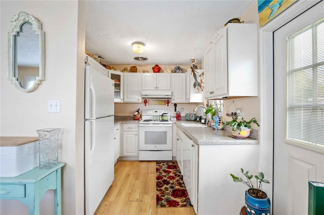 kitchen with white cabinetry, sink, light hardwood / wood-style floors, a textured ceiling, and white appliances