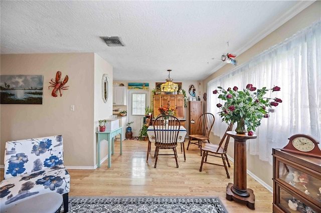 dining area featuring light hardwood / wood-style flooring and a textured ceiling