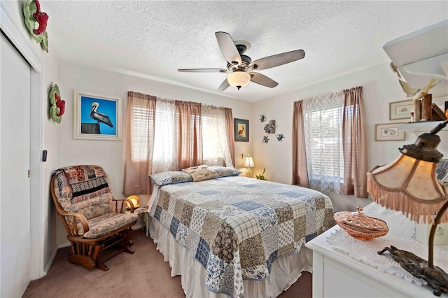 carpeted bedroom featuring ceiling fan, a textured ceiling, and a closet