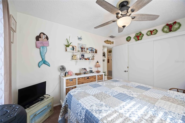 bedroom featuring carpet flooring, ceiling fan, a closet, and a textured ceiling