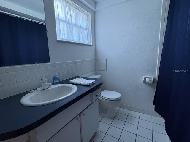 bathroom featuring tile patterned floors, vanity, toilet, and backsplash