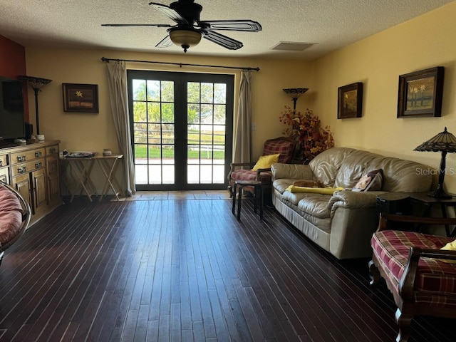 living room with dark hardwood / wood-style floors, ceiling fan, and a textured ceiling