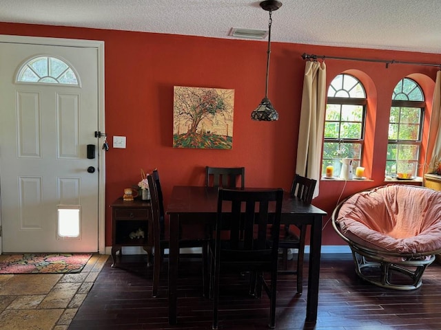 dining room featuring dark hardwood / wood-style flooring, a textured ceiling, and a wealth of natural light