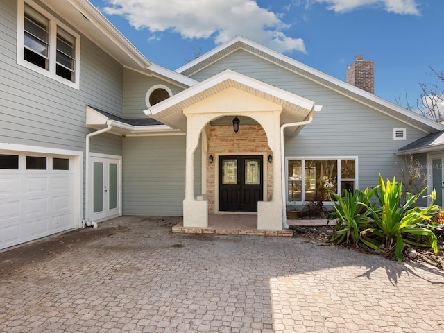 doorway to property featuring french doors, a garage, and a porch