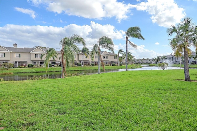 view of home's community featuring a water view and a lawn