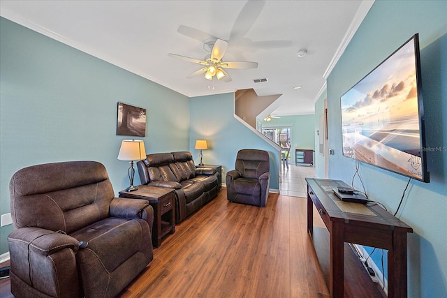 living room with hardwood / wood-style flooring, ceiling fan, and ornamental molding