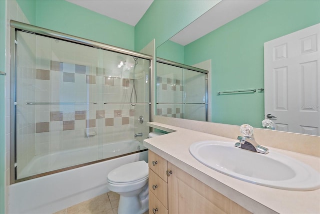 full bathroom with tile patterned flooring, vanity, toilet, and bath / shower combo with glass door