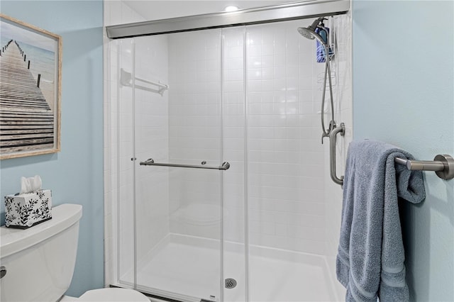 bathroom with toilet and a shower with shower door