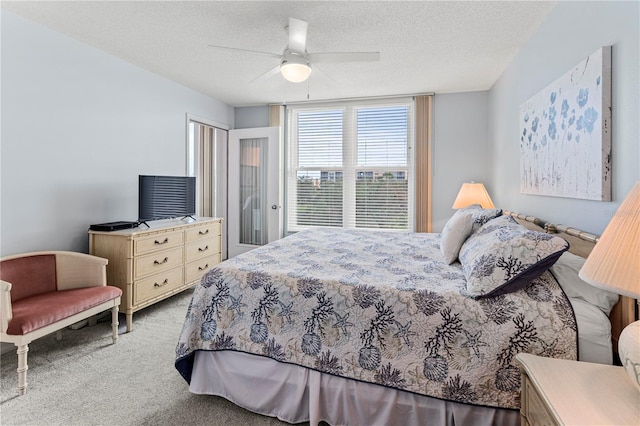 carpeted bedroom with a textured ceiling and ceiling fan