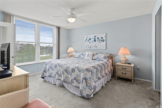 carpeted bedroom featuring ceiling fan and a textured ceiling