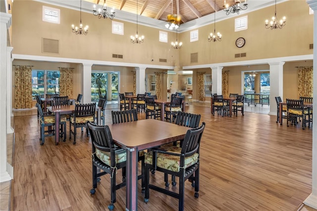 dining space with light wood-type flooring, decorative columns, wood ceiling, high vaulted ceiling, and beamed ceiling