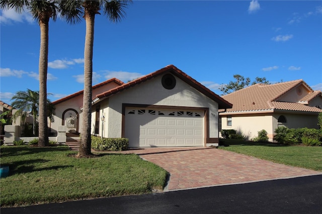 mediterranean / spanish-style home featuring a front yard and a garage