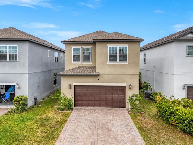 front of property featuring a front lawn, a garage, and central AC