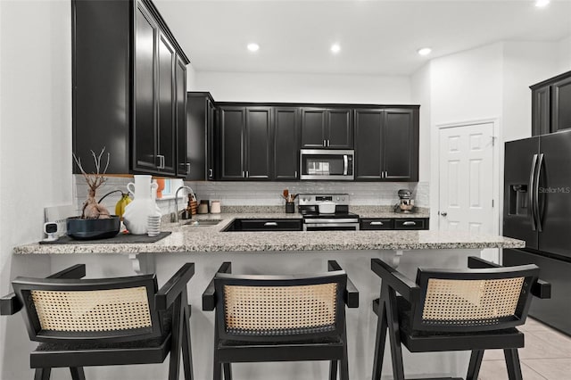 kitchen featuring stainless steel appliances, sink, and a breakfast bar