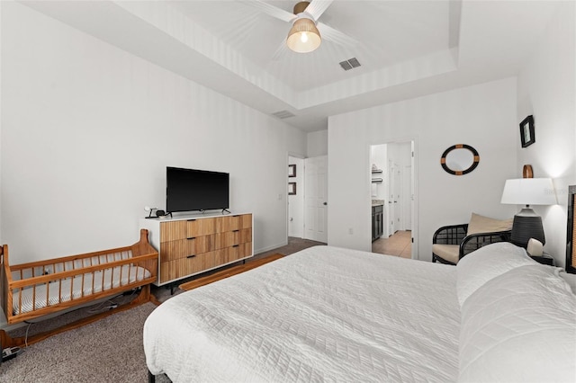 bedroom featuring a raised ceiling and ceiling fan