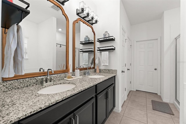 bathroom with tile patterned flooring, vanity, and a shower with door