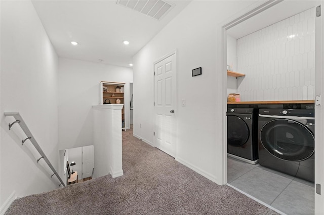 laundry room featuring light colored carpet and washer and clothes dryer