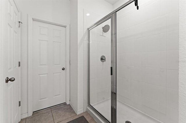 bathroom with tile patterned flooring and a shower with shower door