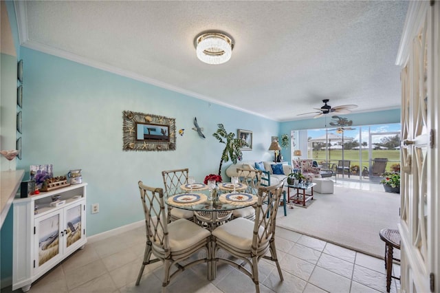 tiled dining room featuring a textured ceiling, ceiling fan, and crown molding