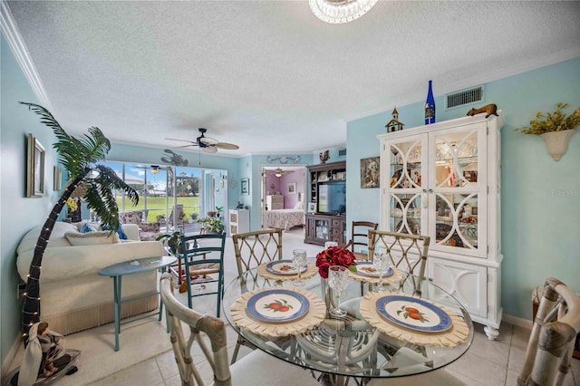 dining space featuring light tile patterned floors, a textured ceiling, ceiling fan, and ornamental molding