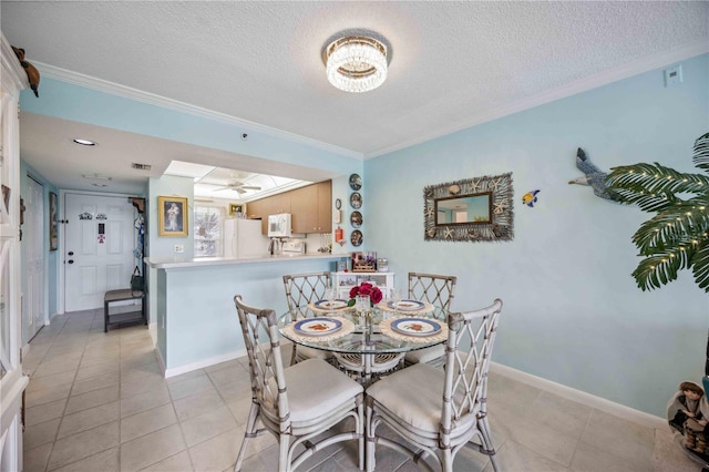 tiled dining room with a textured ceiling, ceiling fan, and ornamental molding