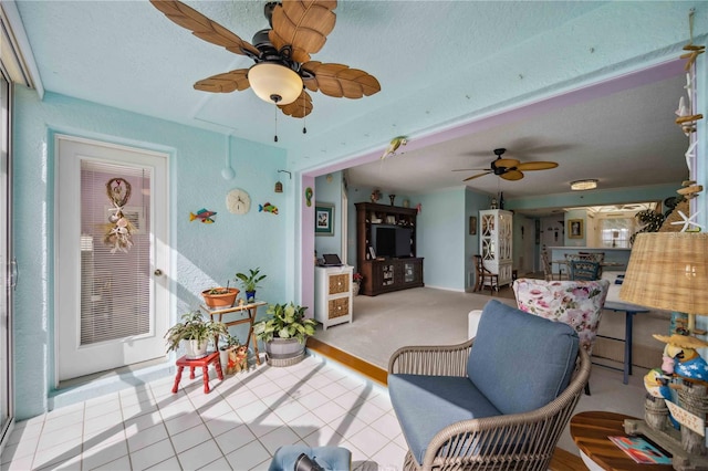 tiled living room with a textured ceiling and ceiling fan