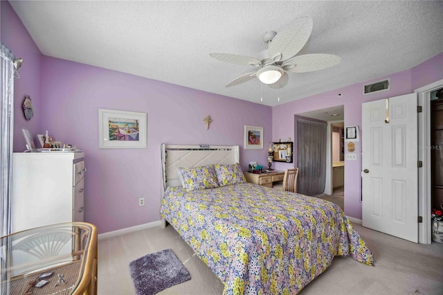 carpeted bedroom featuring ceiling fan and a textured ceiling