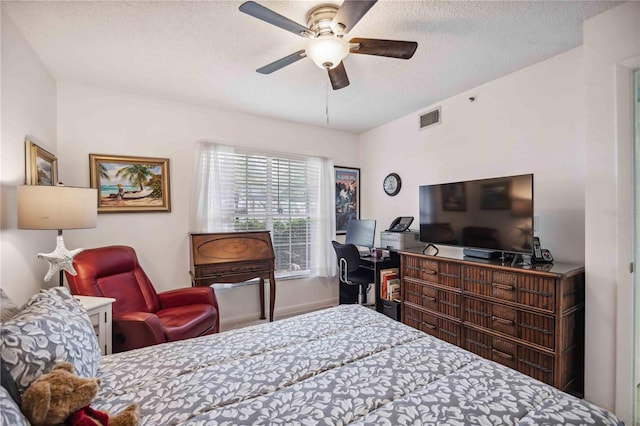 bedroom with ceiling fan and a textured ceiling