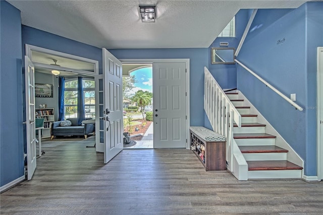 entryway with wood-type flooring, a textured ceiling, and french doors