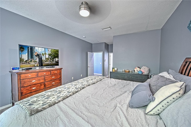 bedroom featuring a textured ceiling, ceiling fan, and lofted ceiling