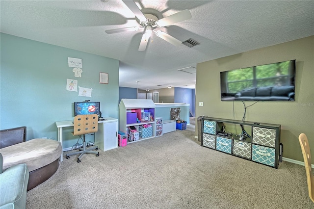 game room with ceiling fan, carpet, and a textured ceiling