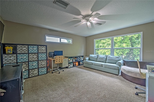 carpeted living room with a textured ceiling and ceiling fan