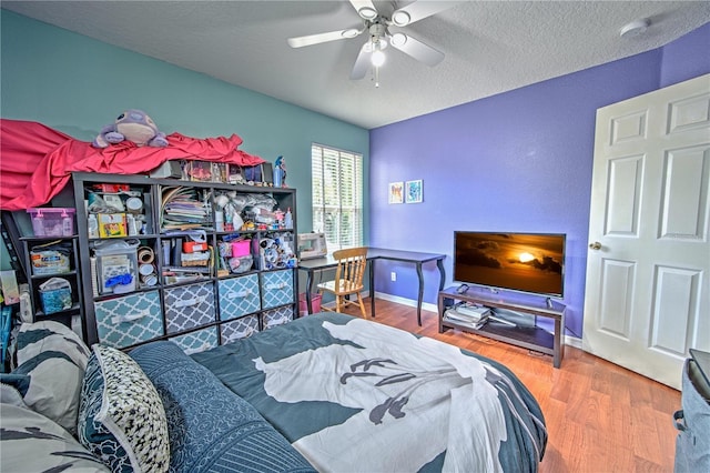 bedroom featuring ceiling fan, wood-type flooring, and a textured ceiling