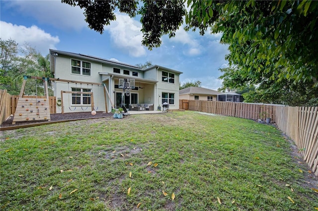 rear view of property featuring a yard, a patio, and ceiling fan