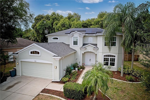 view of front facade featuring a garage and solar panels