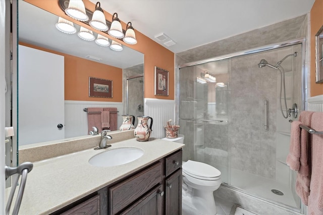 bathroom featuring tile patterned floors, vanity, toilet, and a shower with shower door