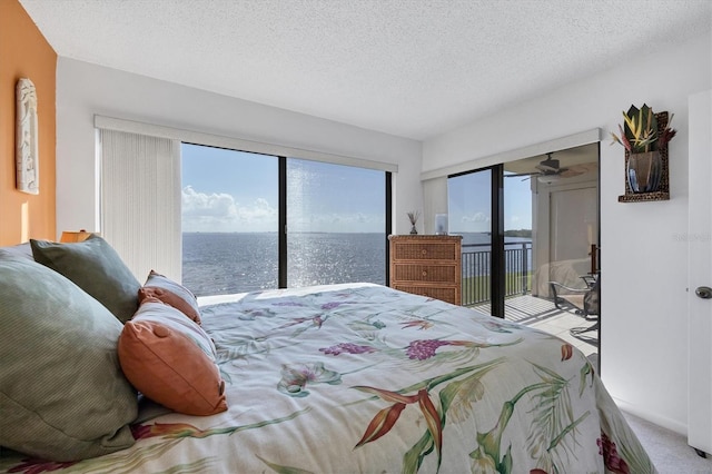 bedroom with access to exterior, a water view, carpet floors, and multiple windows