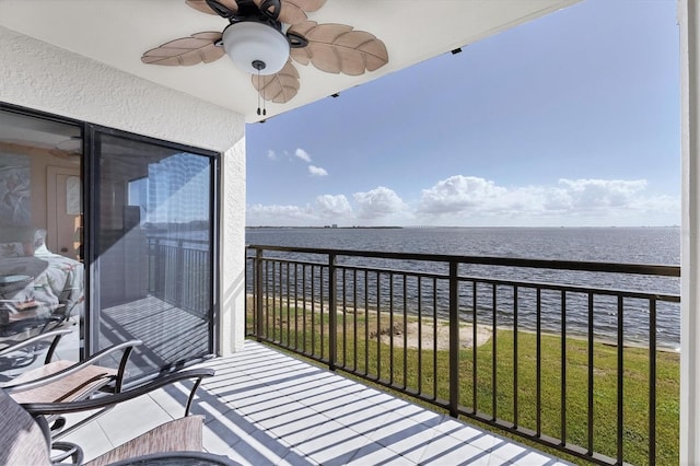 balcony with ceiling fan and a water view