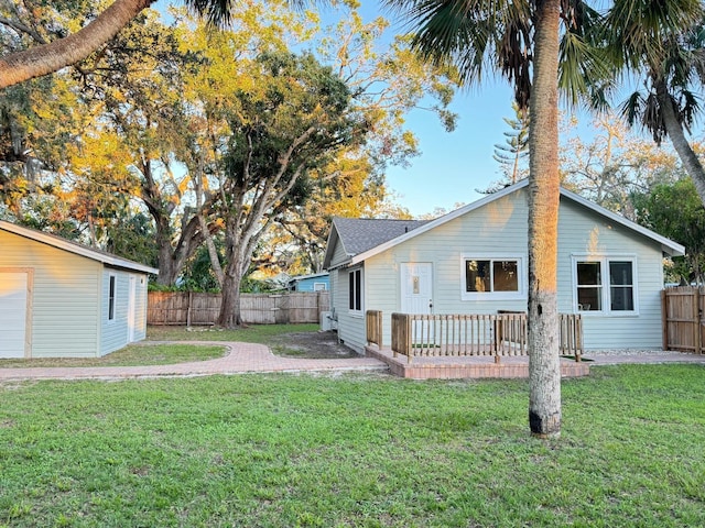 back of property featuring a lawn and a wooden deck