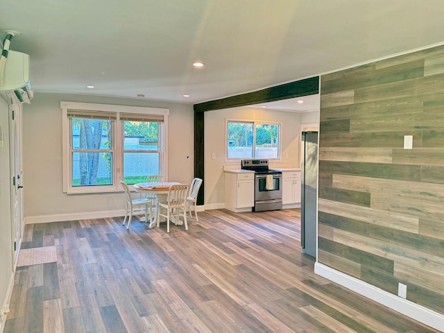 dining area featuring a wall mounted air conditioner and wood-type flooring