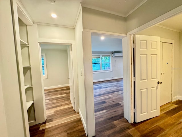 hallway featuring built in features, dark hardwood / wood-style floors, an AC wall unit, and crown molding