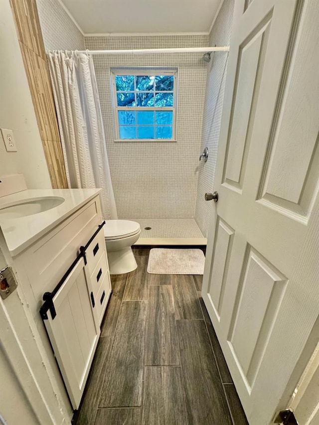 bathroom featuring vanity, toilet, walk in shower, and ornamental molding