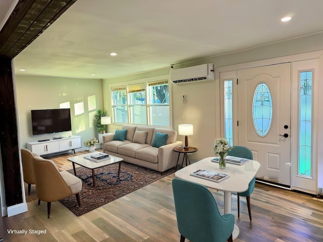 living room featuring hardwood / wood-style flooring and a wall mounted AC