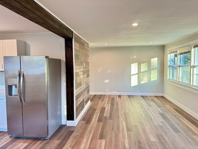 kitchen featuring white cabinetry, wood-type flooring, and stainless steel fridge with ice dispenser