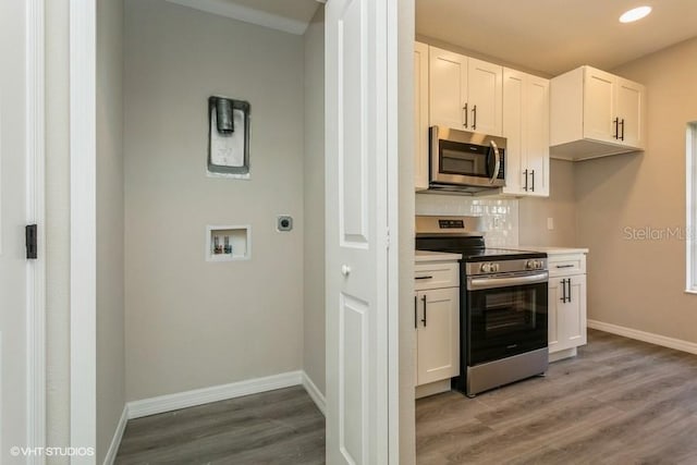 kitchen with hardwood / wood-style flooring, white cabinetry, appliances with stainless steel finishes, and tasteful backsplash