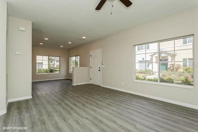 unfurnished living room with dark hardwood / wood-style floors and ceiling fan