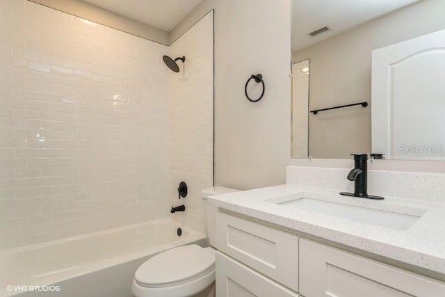 full bathroom with vanity, tiled shower / bath combo, and toilet